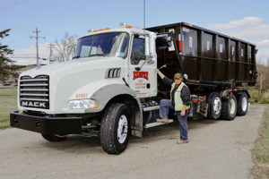 Driver Picking Up Construction Dumpster